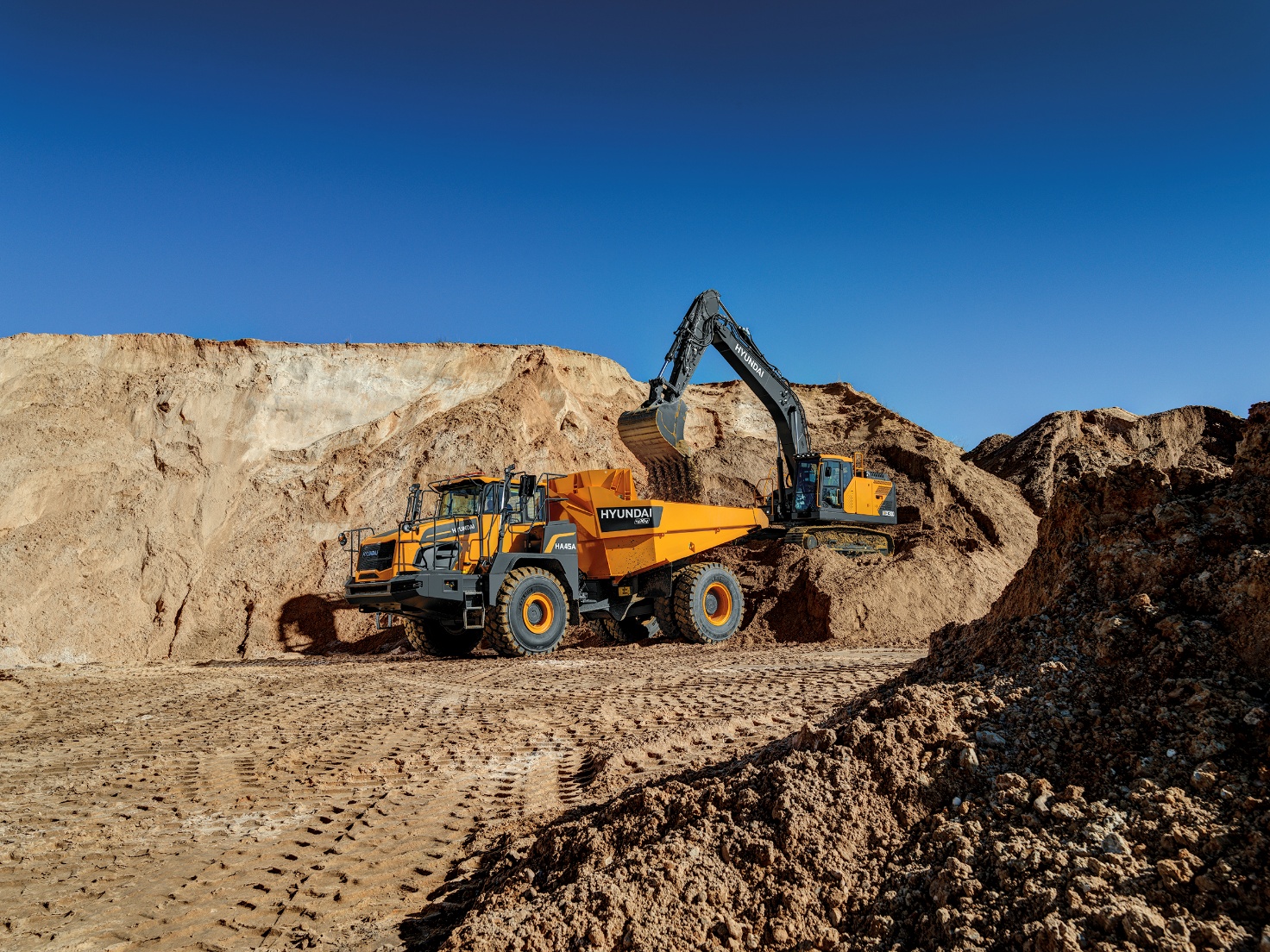 Autobasculantă articulată Hyundai și excavator la lucrări de infrastructură